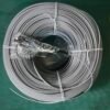 Provide top-down view of coiled cable for product presentation. Top-down view of gray fiber optic coil with bubble-wrapped connector on green surface.