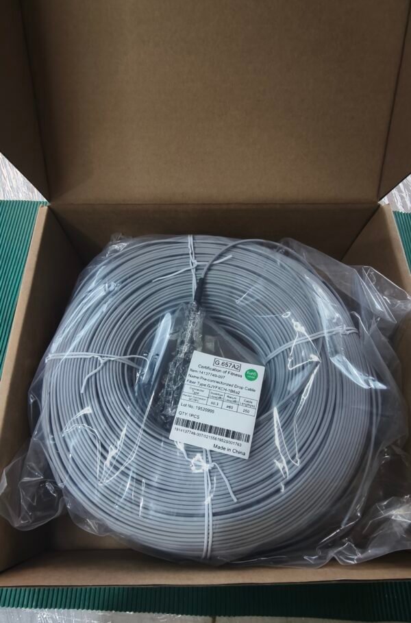 Illustrate packaged cable in open box for unboxing or sales demo. Open cardboard box containing plastic-wrapped gray fiber optic cable coil with label.